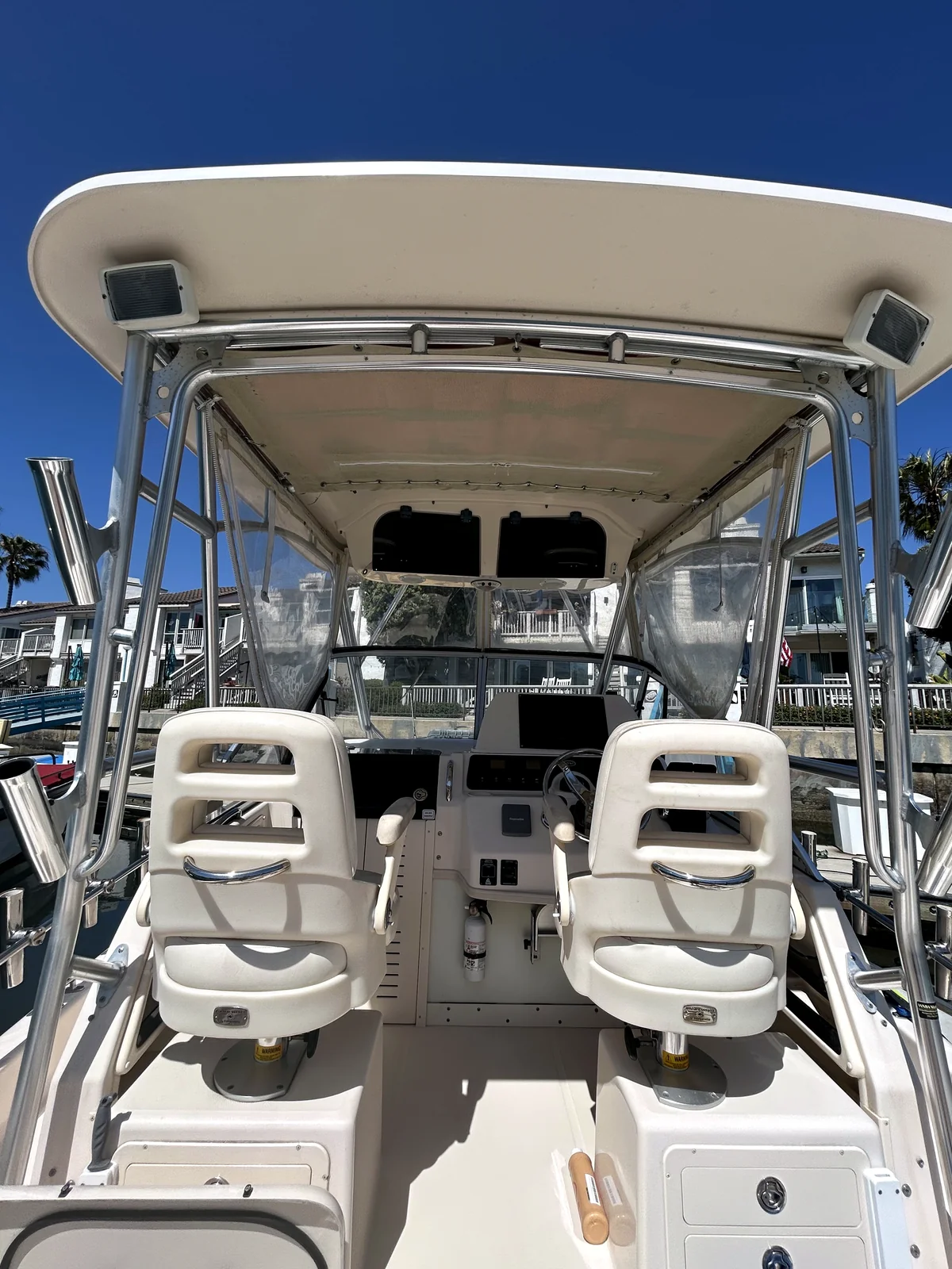 Center-console yacht with palm trees and Mediterranean architecture at a San Diego marina