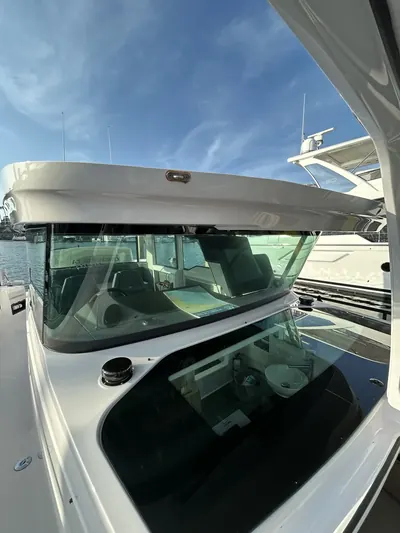 Gleaming windshield and helm of a white cabin yacht after a HarborSide detail