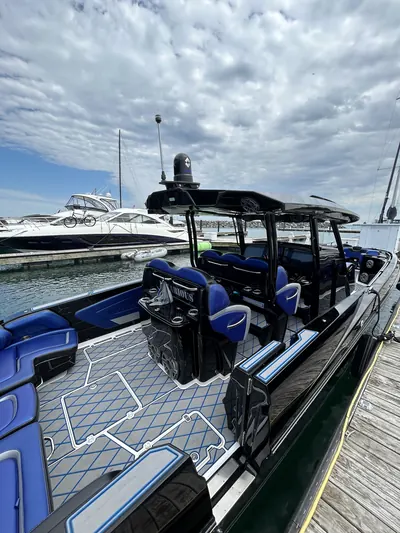 Black center-console powerboat with blue seating and gray decking docked at the marina after a HarborSide detail
